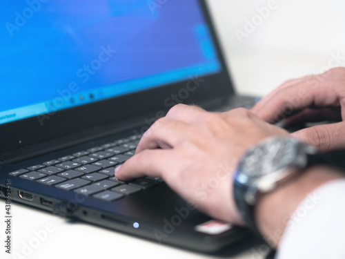 Businessman reading online documents on laptop screen with magnifying glass concept for analyzing a finance agreement or legal contract