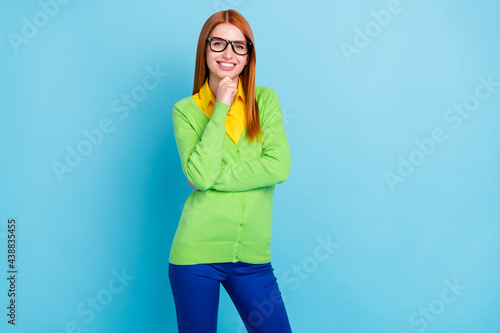 Photo of smart young student lady touch face wear green sweater trousers isolated on blue color background