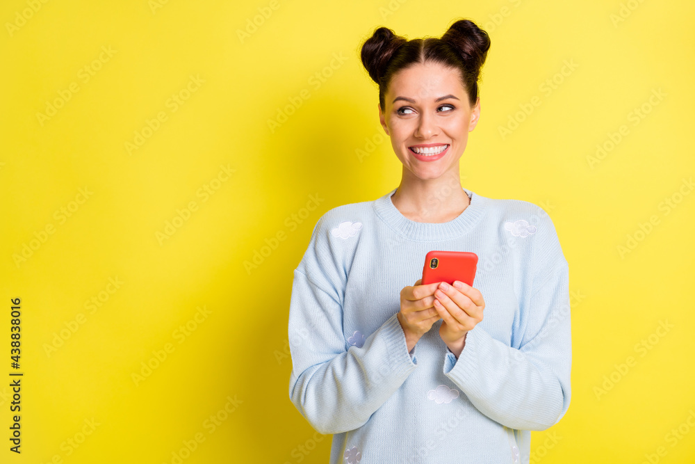 Photo of lady hold telephone look side empty space toothy smile wear blue sweater isolated yellow background Photo of lady hold telephone look side empty space toothy smile wear blue sweater isolated yellow background
