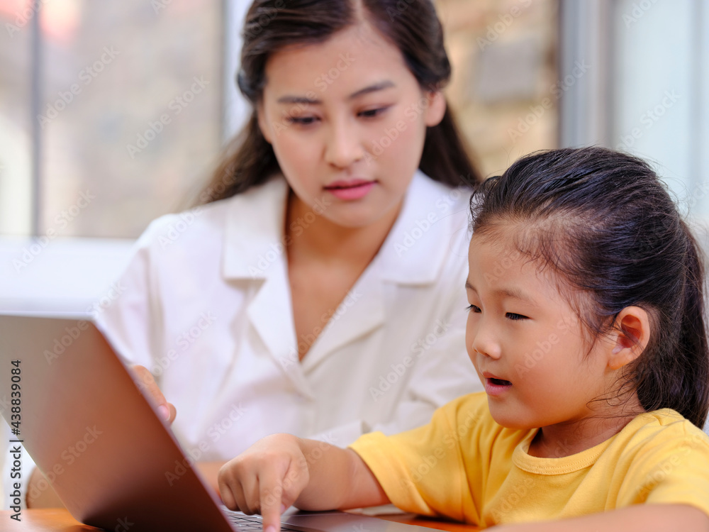 Young Happy mother and daughter use laptops Young Happy mother and daughter use laptops