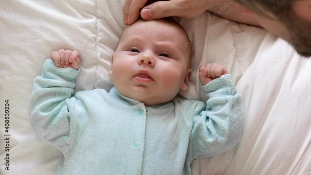 Father with his Daughter, tiny infant. Newborn baby smiling, laughing and looking up at him. Daddy showing affection to baby. Authentic video of beard Dad caressing his newborn baby. Slow Motion.