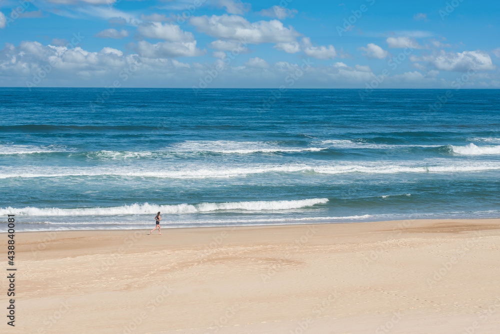 beautiful landscape of the coast in the south west of France with a jogger on the beach