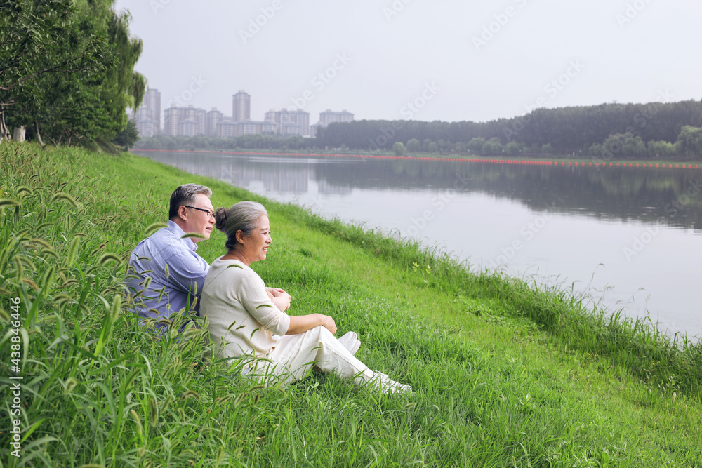 Happy old couple watching the scenery by the lake