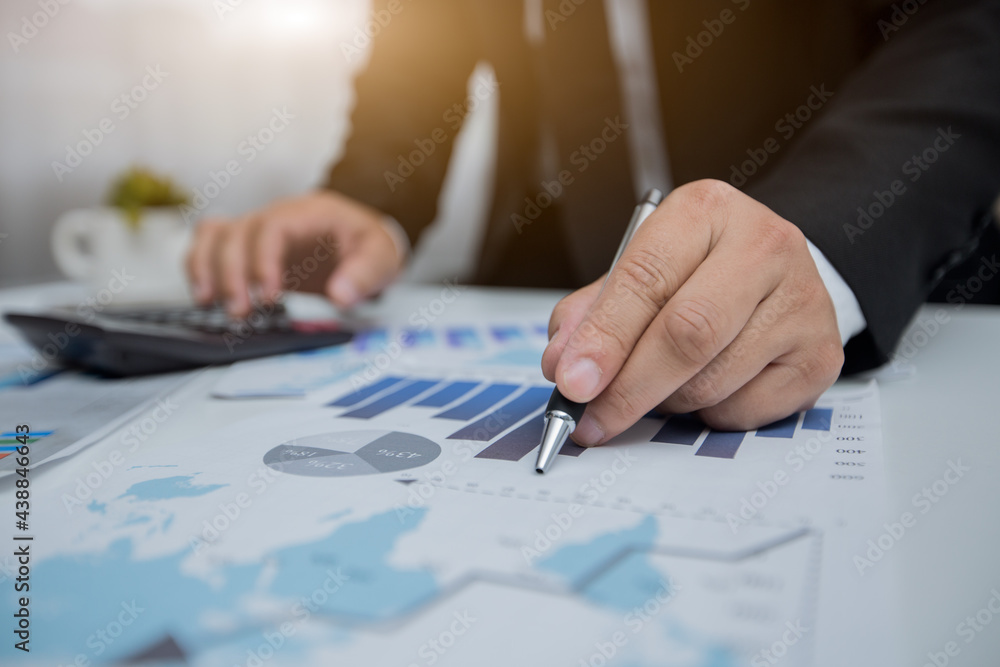 Businessman counting on calculator and reviewing budget on business Businessman counting on calculator and reviewing budget on business