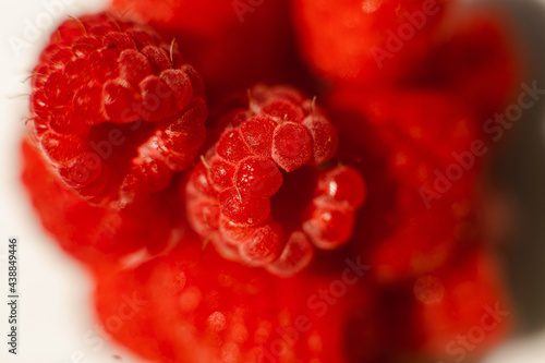 Beautiful raspberries in triangle shape lies isolated on a white background. Cut out, close up. Background and picture for postcard