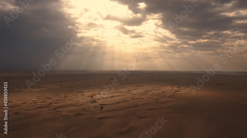 AERIAL. Sunset light shines across Great Sand Dunes at UAE. HDR dramatic sunset in desert.