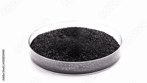 graphite powder used in industry, black powder with isolated white background and copy space.