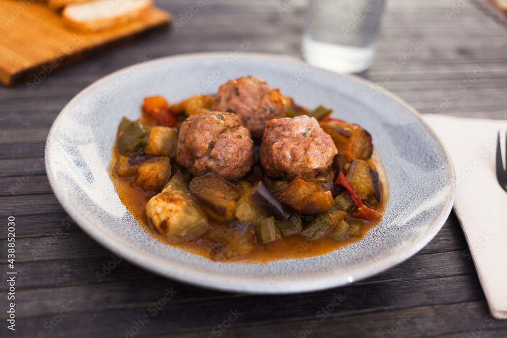 baked meatballs with stewed eggplant, zucchini, green peppers and tomatoes with haze in bowl baked meatballs with stewed eggplant, zucchini, green peppers and tomatoes with haze in bowl
