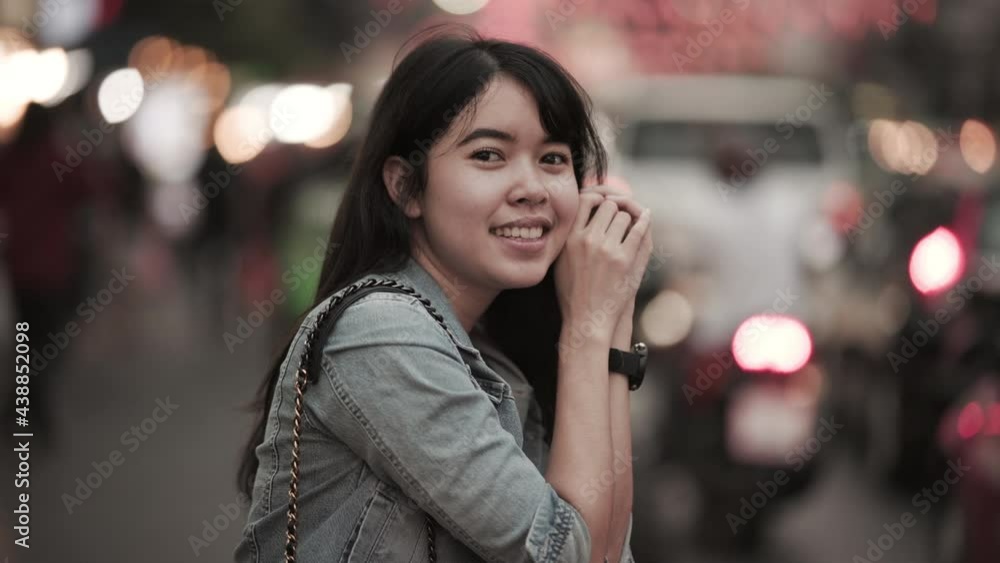 A beautiful Asian female who has long hair travels to the festival at Yaowarat Chinatown in Thailand. Street photography of traveler woman at night. Woman smiling. A beautiful Asian female who has long hair travels to the festival at Yaowarat Chinatown in Thailand. Street photography of traveler woman at night. Woman smiling.