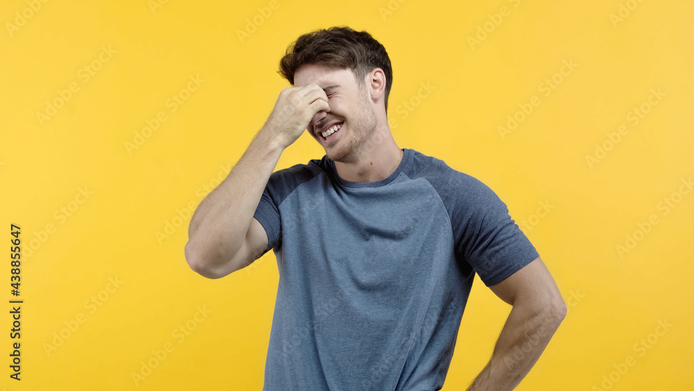 Positive man holding hand near eyes isolated on yellow Positive man holding hand near eyes isolated on yellow
