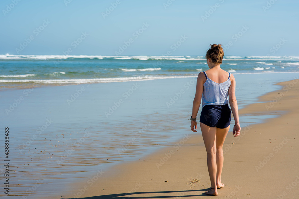 beautiful young woman walking alone on the sunny beach beautiful young woman walking alone on the sunny beach