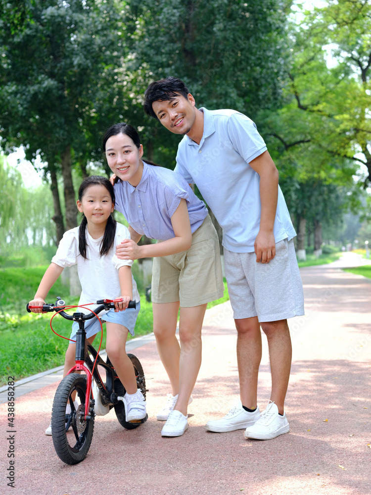 Parents teach their children to ride bicycles Parents teach their children to ride bicycles