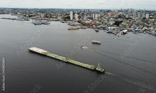 A tug push three ferry boats in Negro river near the city of Manaus, Amazonas state, Brazil. photo