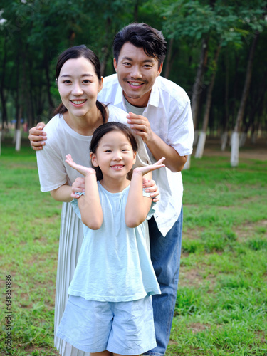 Happy family of three playing in the park