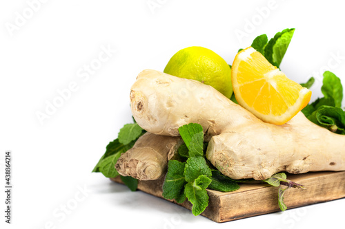 Ginger root  green fresh mint and lemons on wooden tray.