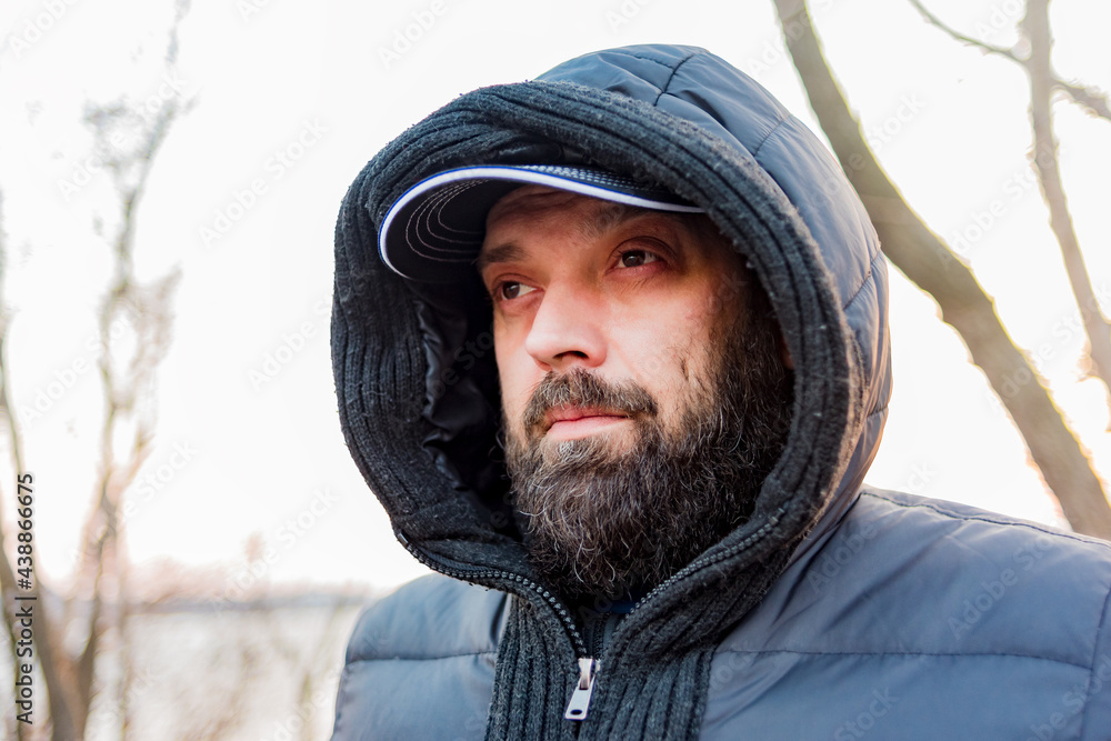 Headshot of a man in a hood. Man in a gray jacket with a hood. Headshot of a man in a hood. Man in a gray jacket with a hood.