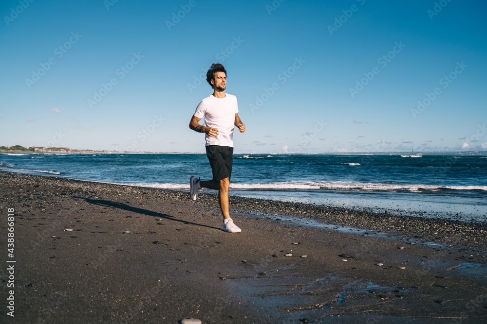 Fit young man running on beach