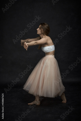 Young girl in white top and peach skirt dancing
