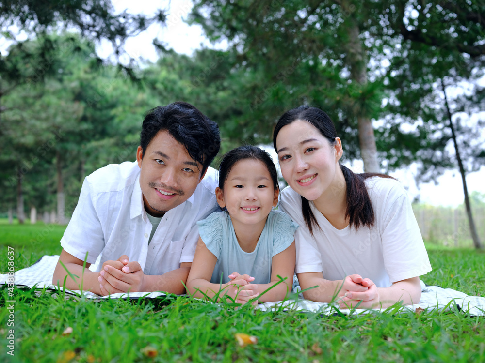 Happy family of three playing in the park Happy family of three playing in the park