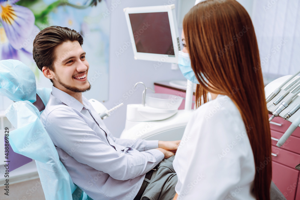 Obraz premium Dentist woman examining a patient's teeth in the dentistry. Overview of dental caries prevention. Healthy teeth and medicine concept.
