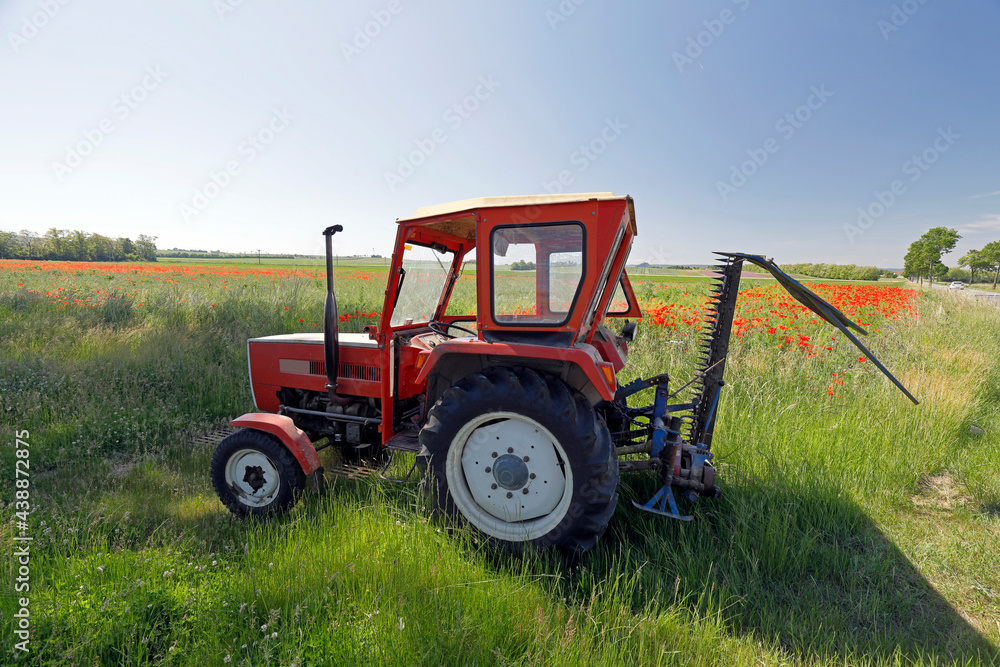 Ein Traktor in der Kulturlandschaft des Weinviertels im Bereich von Wiesen und Feldern Ein Traktor in der Kulturlandschaft des Weinviertels im Bereich von Wiesen und Feldern