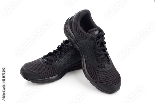 Black sneakers isolated on white background. Stylish black sneaker made from a combination of faux leather and textile material and rubber sole. Casual shoes. Running shoes.