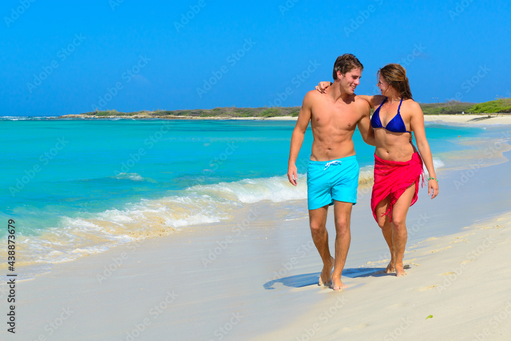 Young beautiful couple walking and relaxing on the beach Young beautiful couple walking and relaxing on the beach