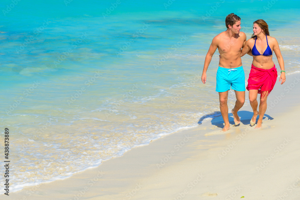 Young beautiful couple walking and relaxing on the beach Young beautiful couple walking and relaxing on the beach