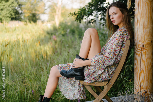beautiful woman in a summer dress and boots e stylish wooden dress.