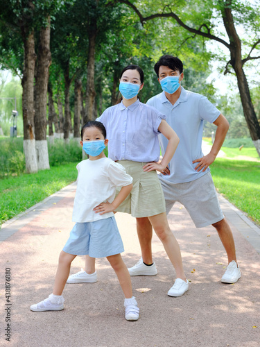 A young family of three with masks