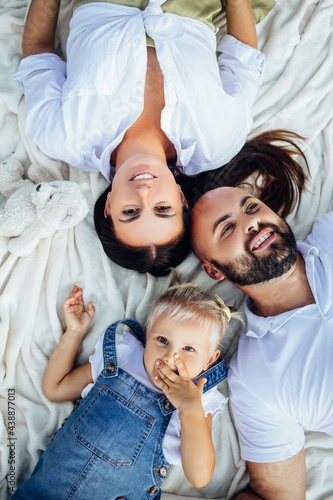 Young beautiful family with a little blonde daughter in denim clothes. 