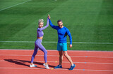 Sport success. male and female coach on stadium running track arena. healthy lifestyle. sport couple celebrate team win. fitness partners. athletic man and sexy woman compete in armwrestling