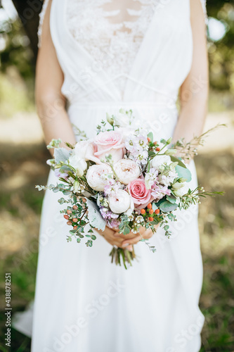Bride holding wedding bouquet with white and pink flowers