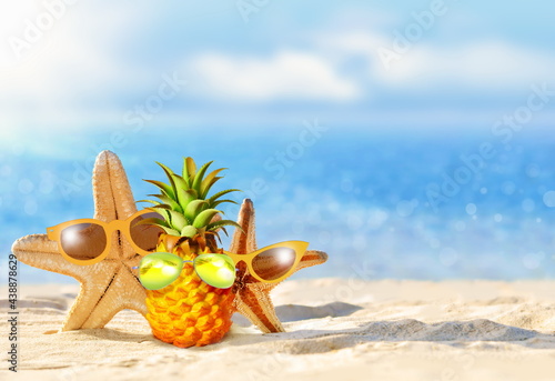 Pineapple and starfish with sunglasses in the beach. Summer concept.