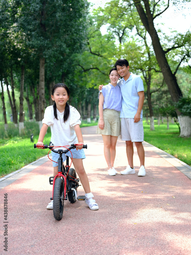 Parents teach their children to ride bicycles Parents teach their children to ride bicycles