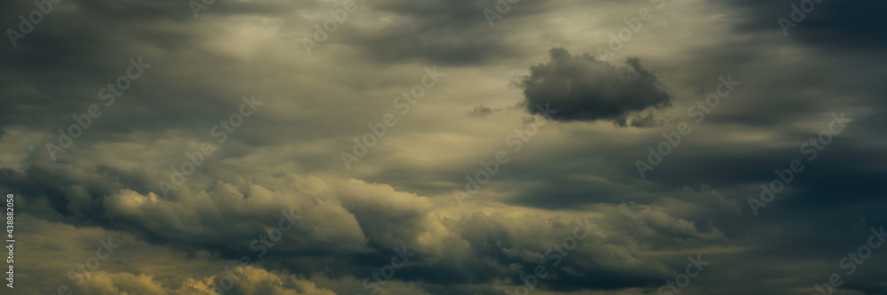 wide panoramic view of the dark opaque dramatic stormy sky with dense cumulus clouds and atmospheric haze. artistic moody cloudscape