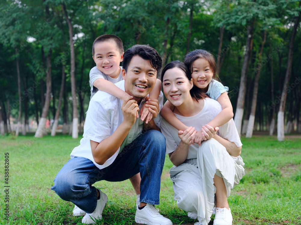 Happy family of four playing in the park