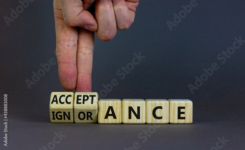Acceptance or ignorance symbol. Businessman turns cubes, changes the word 'ignorance' to 'acceptance'. Beautiful grey table, grey background. Business, acceptance or ignorance concept. Copy space.