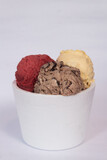 An isopor container with ice cream of different flavors, on a white background.