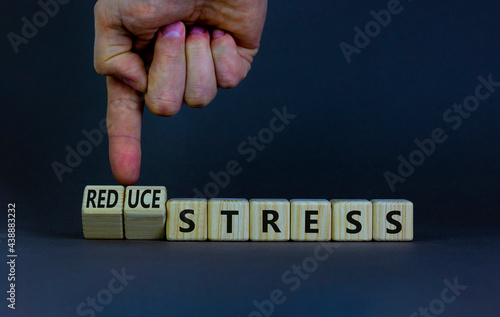 Reduce stress symbol. Businessman turns cubes and changes words 'stress' to 'reduce stress'. Beautiful grey background. Medical, psychological, reduce stress concept. Copy space.