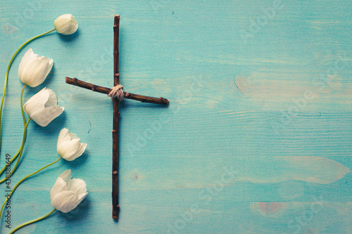 Canvas Print Christian cross with white flowers on blue wood background