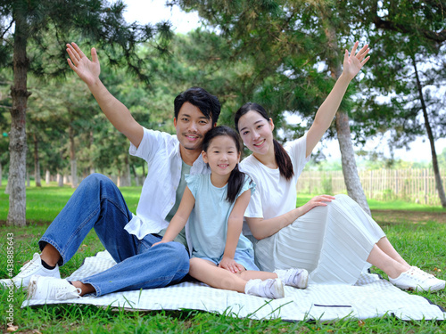 Happy family of three playing in the park