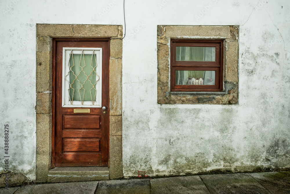 Door and window of an old building made of stone plastered with lime filled Door and window of an old building made of stone plastered with lime filled
