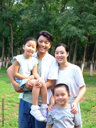Happy family of four playing in the park