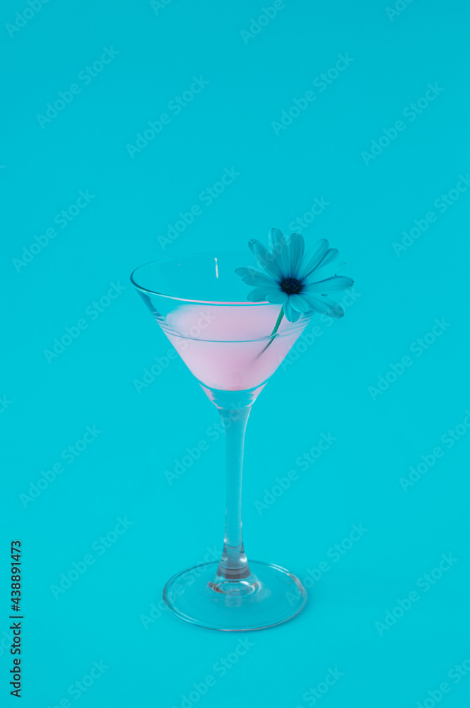 Pink neon cocktail on blue background with decorative flower. Pink neon cocktail on blue background with decorative flower.