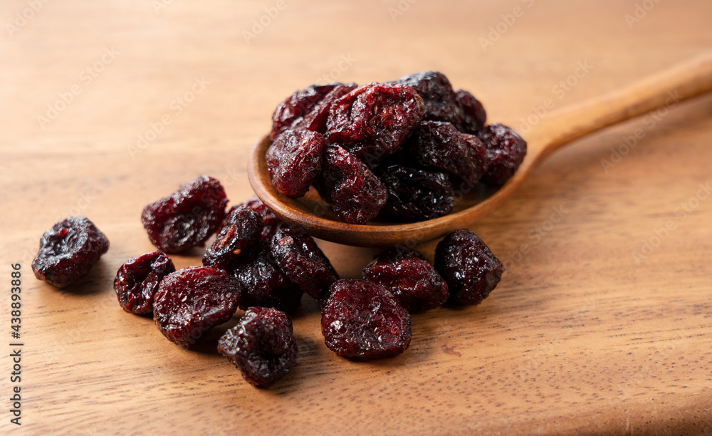 Dried cranberries with a wooden spoon on a wooden background. Dried cranberries with a wooden spoon on a wooden background.