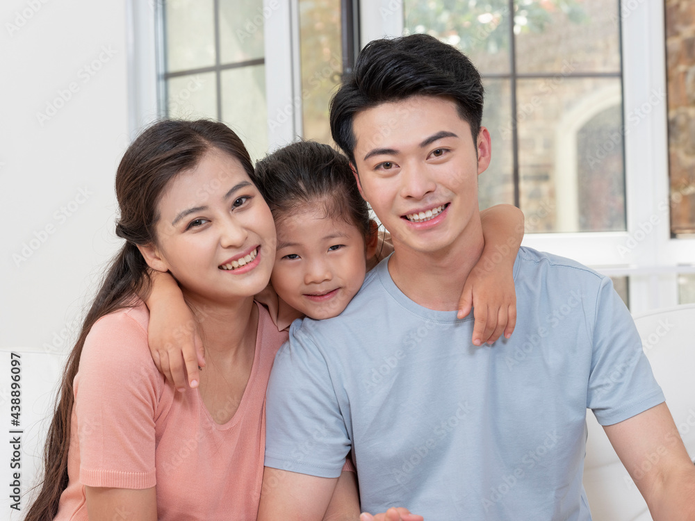 A happy family of three is sitting on the sofa in the living room A happy family of three is sitting on the sofa in the living room