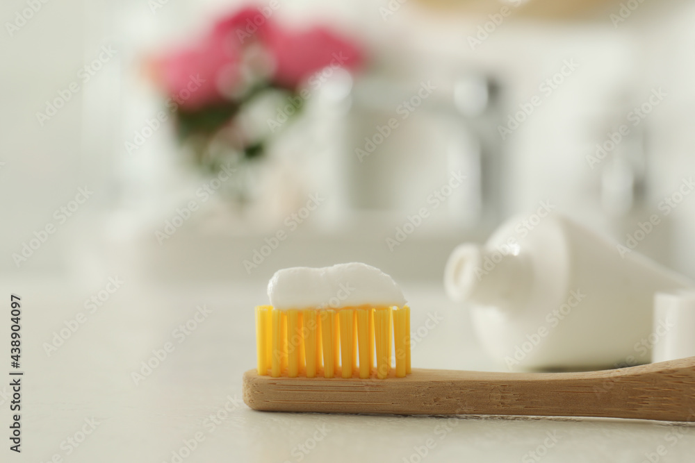 Brush with toothpaste on bathroom counter, closeup. Space for text Brush with toothpaste on bathroom counter, closeup. Space for text