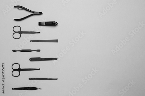 Set of manicure tools on grey background, flat lay. Space for text