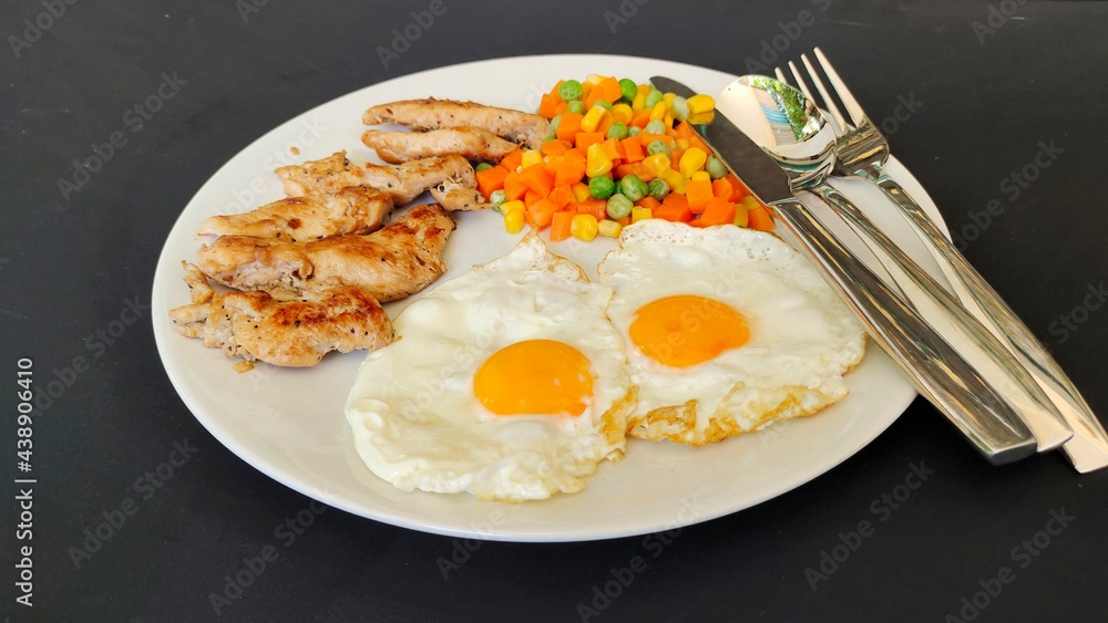 fried eggs with chicken and vegetables. fried eggs with chicken and vegetables.